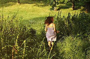 woman in brown spaghetti strap dress running on grass field