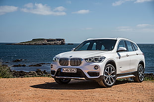 white BMW SUV parked near seashore during daytime