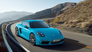 blue Porsche 911 running on concrete road during daytime