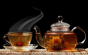 photo of clear glass teapot and teacup with tea