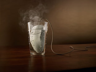 gray corded computer mouse in cup of hot water