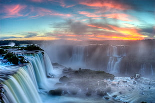 photography of waterfalls under orange and blue sky during sunset
