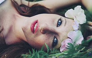 woman lying on green grass photography
