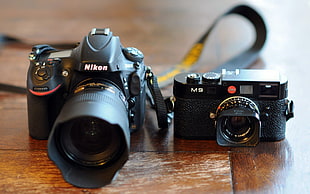 closeup photography of Nikon DSLR camera beside black MILC