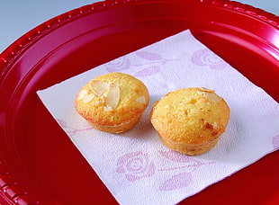two baked muffins on white tissue paper