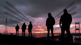 silhouette of people standing behind bridge