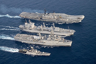 four gray battle ships in the sea