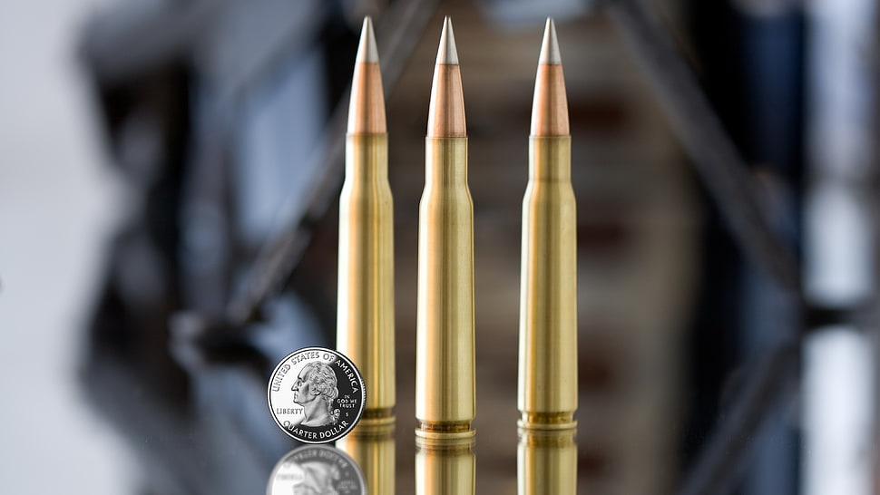 three bullets with round silver coin HD wallpaper