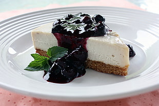 cheese cake with berries syrup on white ceramic plate