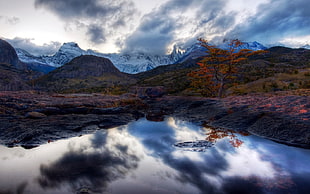 body of water between mountain during daytime HD wallpaper