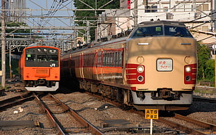 two beige and orange trains