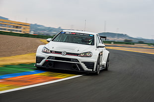 white Volkswagen racing sedan on track