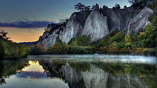 gray mountain beside body of water HD wallpaper