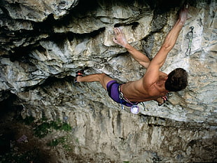topless man doing rock climbing