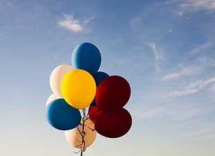 assorted-colored balloons floating on air under blue sky