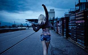 woman with tattoo covered back walking on road, women, jean shorts, tattoo, leather jackets