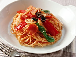 pasta with variety of toppings on round white ceramic bowl