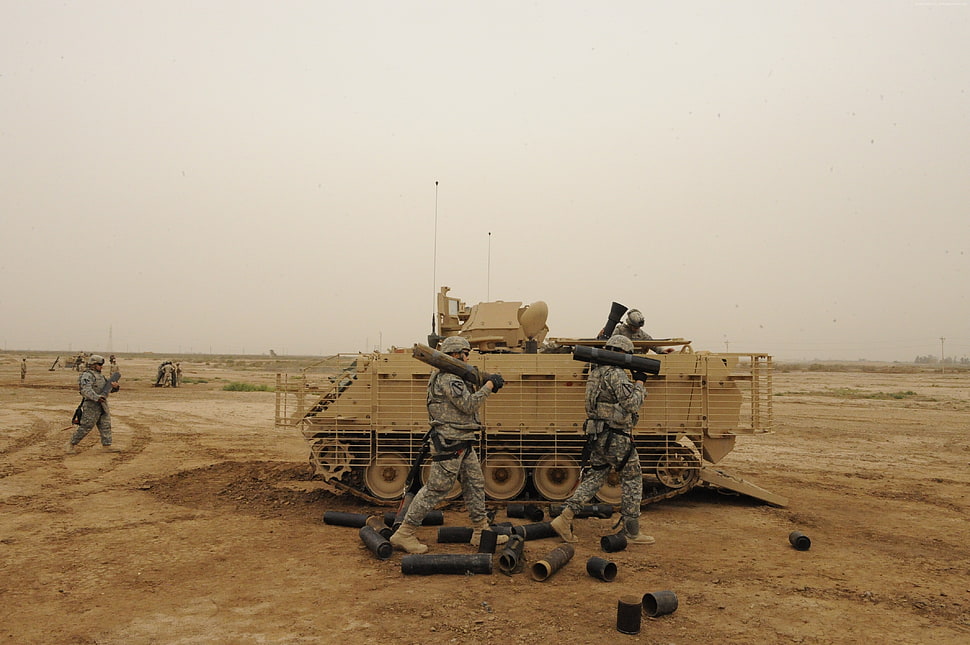 soldiers walking beside battle tank on dessert HD wallpaper