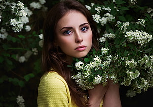 woman wearing yellow tops holding white flowers closeup photography