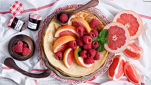 sliced orange and strawberries on round white plate