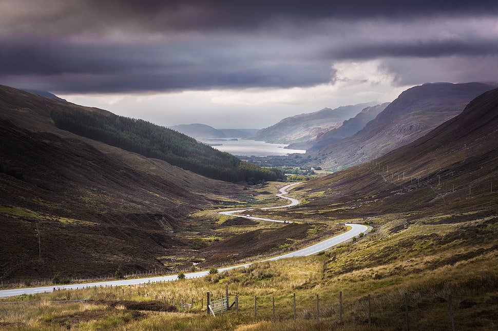road passing through mountains HD wallpaper