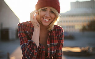 woman in plaid shirt and beanie smiling
