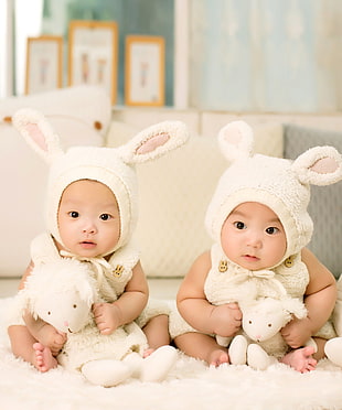 two baby in white rabbit costumes