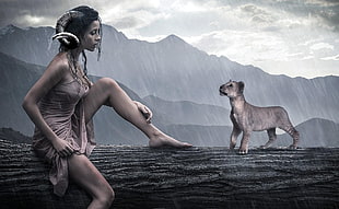woman with horn sitting on trunk beside lion cub during raining HD wallpaper