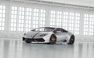 silver Lamborghini Huracan inside room with white wall and floor