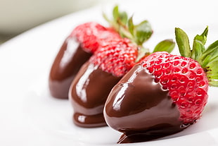 selective focus photography of three chocolate dipped strawberries