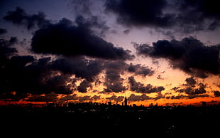 brown and black abstract painting, sunset, cityscape, sunlight, clouds