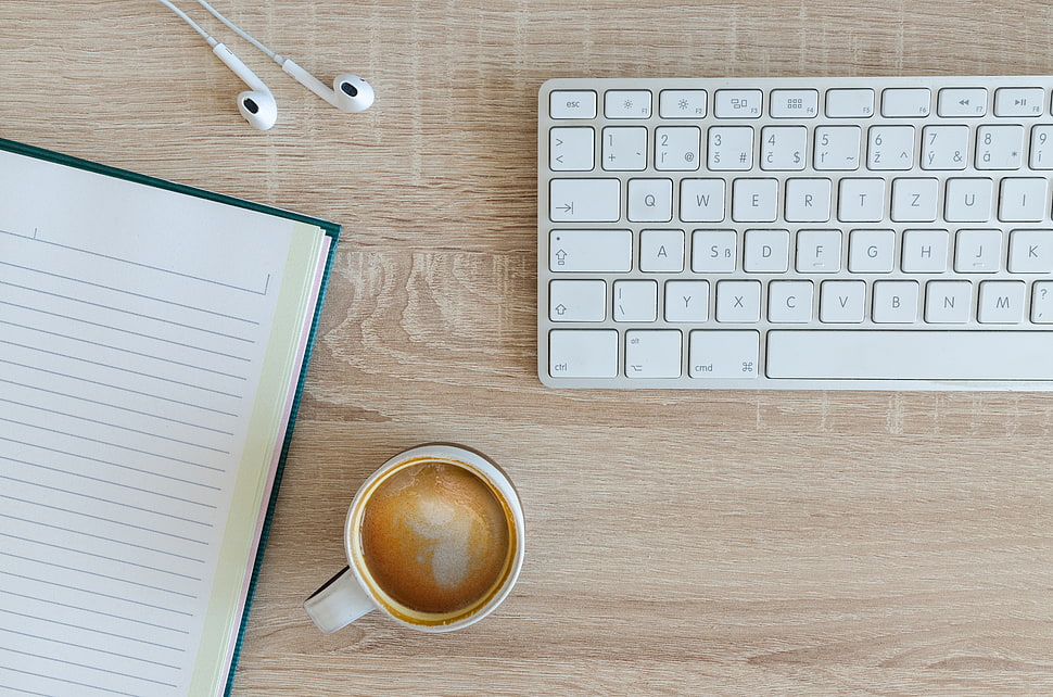 Apple Magic Keyboard beside white ceramic mug and white lined paper HD wallpaper