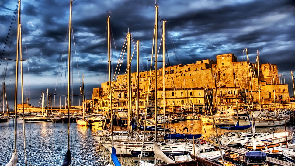 white boats parked on sea near building under cloud formation wallpaper HD wallpaper