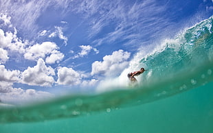 woman in the act of surfing during daytime low angle photography