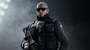 man in black tactical suit holding rifle