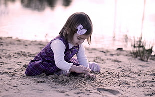 girl's in purple dress playing sand