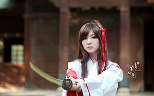 woman in white dress holding sword near temple during daytime