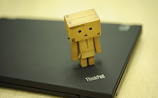 brown minifigure toy on black laptop computer