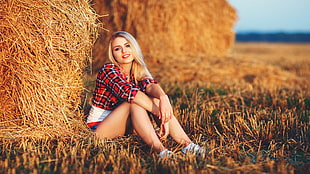 woman sitting next to hay bale