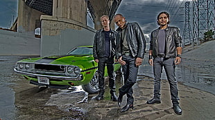 three man wearing black leather jacket near green car