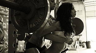 grayscale photography of woman lifting barbell