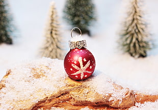 red and white Christmas bauble on white and brown surface