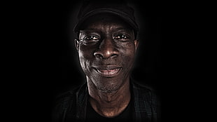 photo of man in black crew-neck shirt and cap