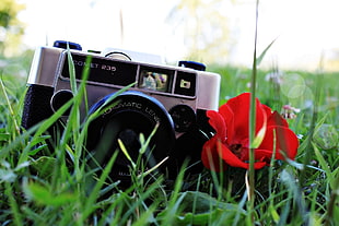 black and gray DSLR camera on green pasture