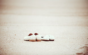 two pairs of women's white shoes on ground