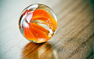 selective focus photography of orange clear marble