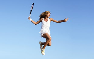women jumping while tennis racket