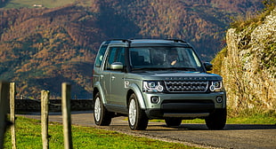 gray Land Rover Discovery on dirt road near grass during daytime