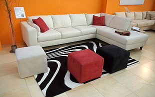 white leather sectional sofa filled with 2 red throw pillows HD wallpaper