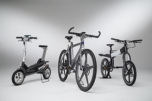 two gray bikes and motorized scooter